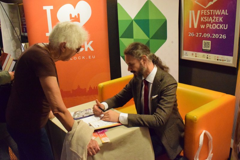 IV Festiwal Książek w Płocku - dzień drugi - Radek Rak rozdaje autografy na książkach (fot. PJ)  